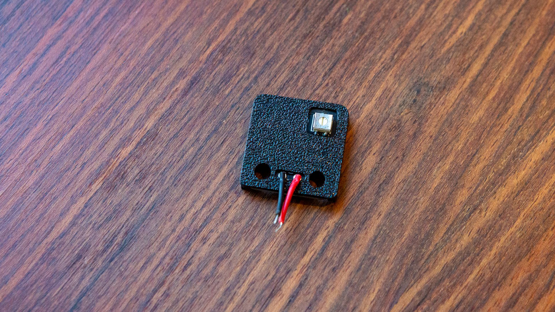 The tracking sensor replacement with its wires attached